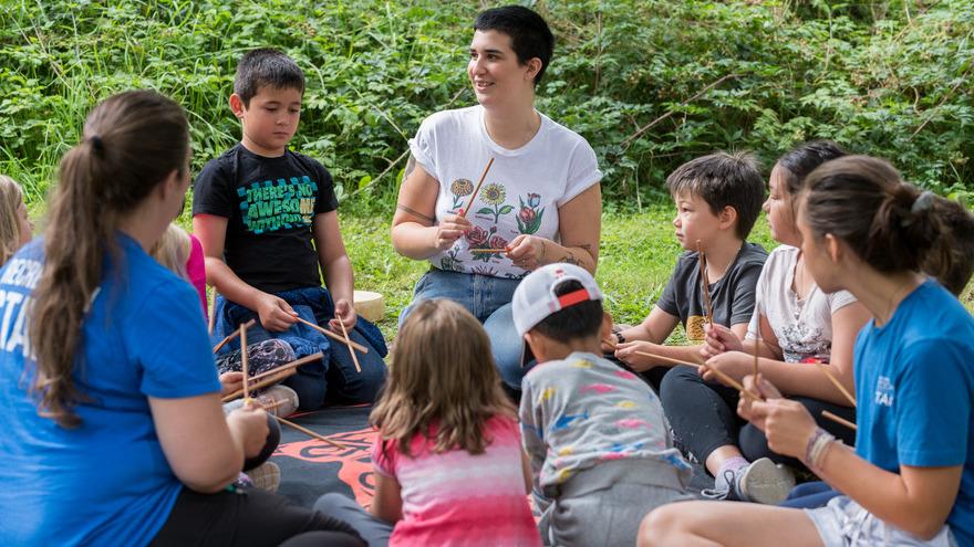 Greg Moore Youth Centre staff sit with kids in a circle outside.