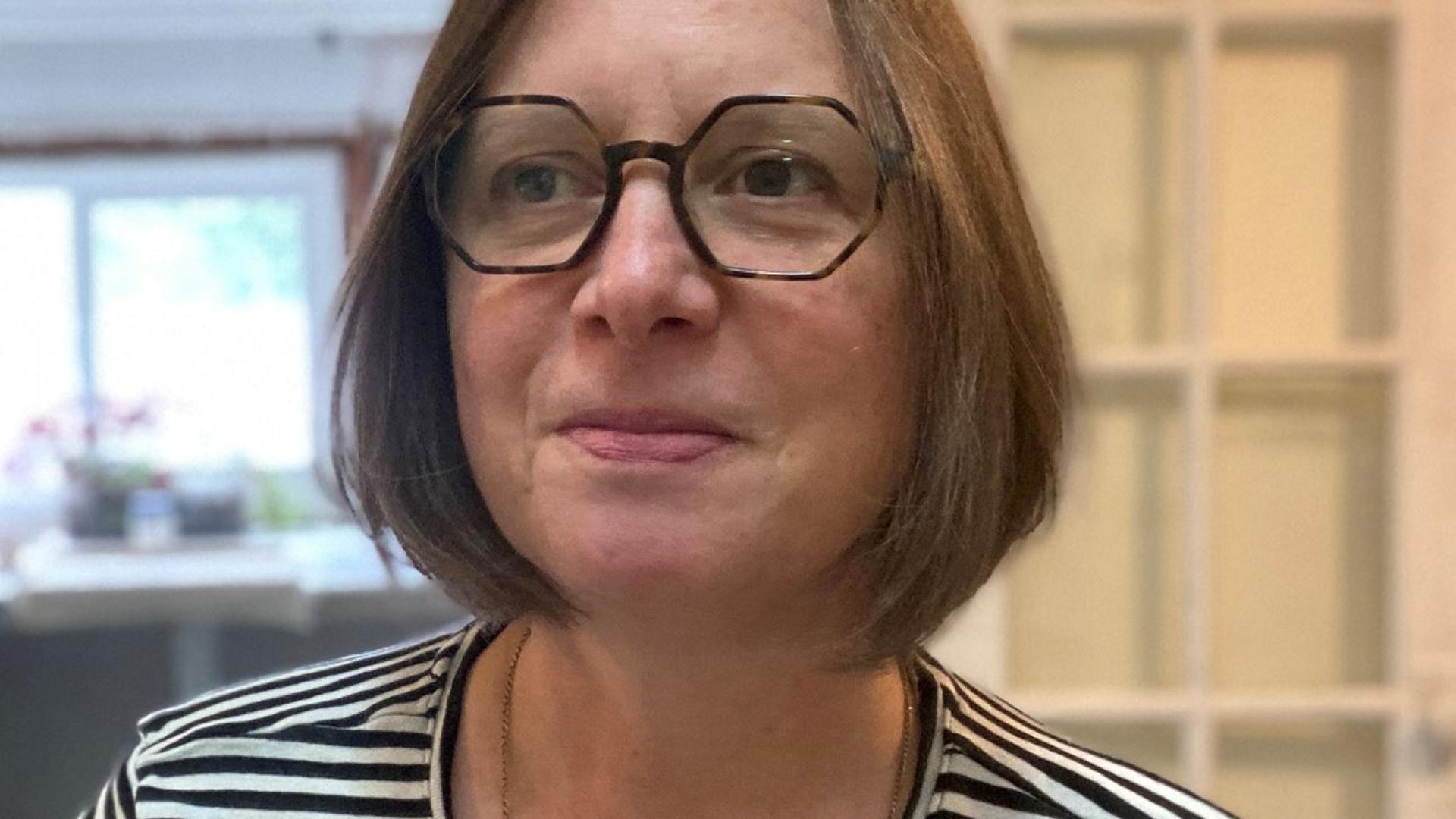 Profile picture of Colleen Brown. There is a person with medium length hair, dark rimmed eyeglasses and a black and white striped shirt. 