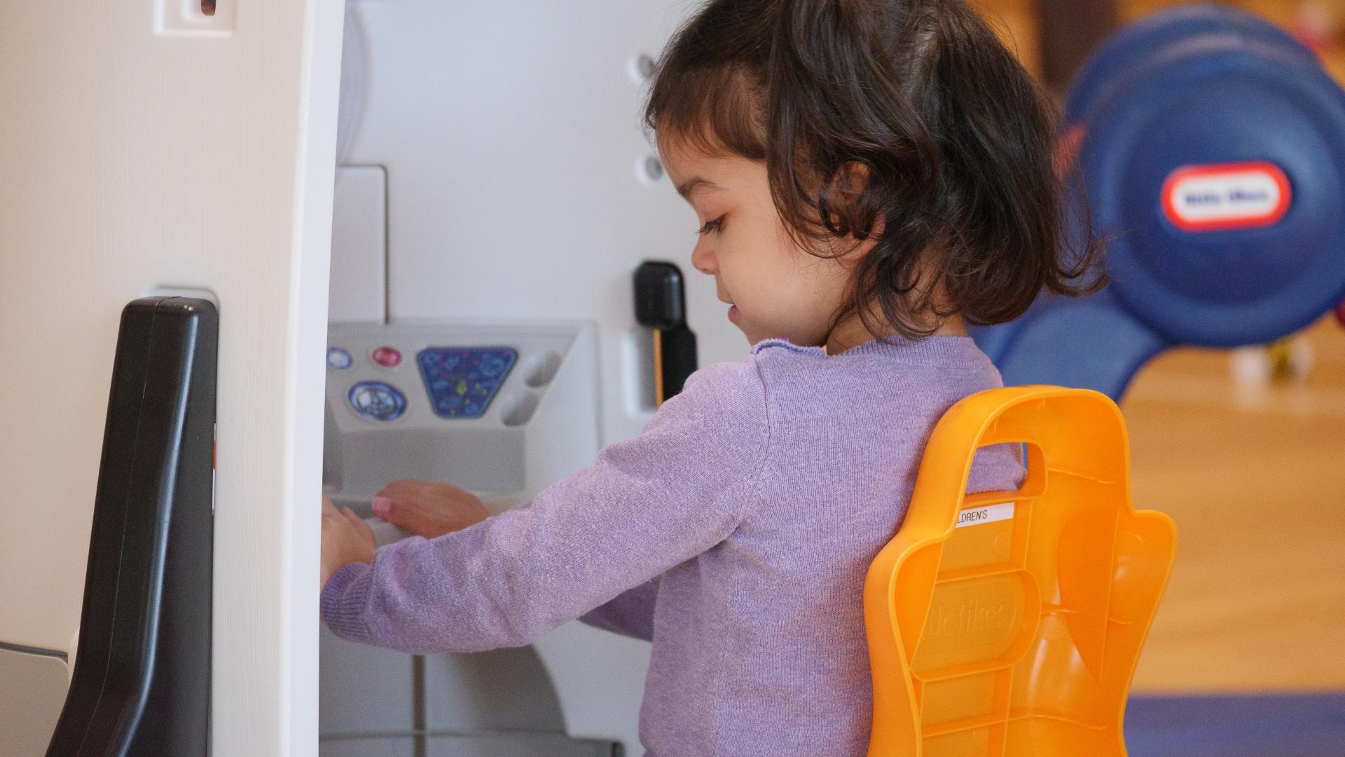 Little Girl Playing with Play Equipment in a Gym