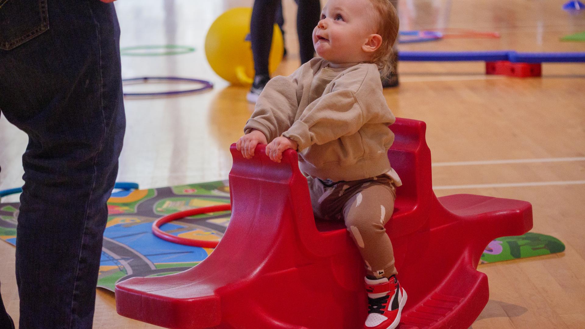 Little Boy on a Rocking Toy in a Gym