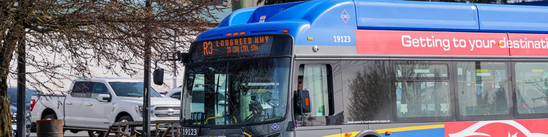 A Translink bus travels down Lougheed Highway towards Maple Meadows Station.