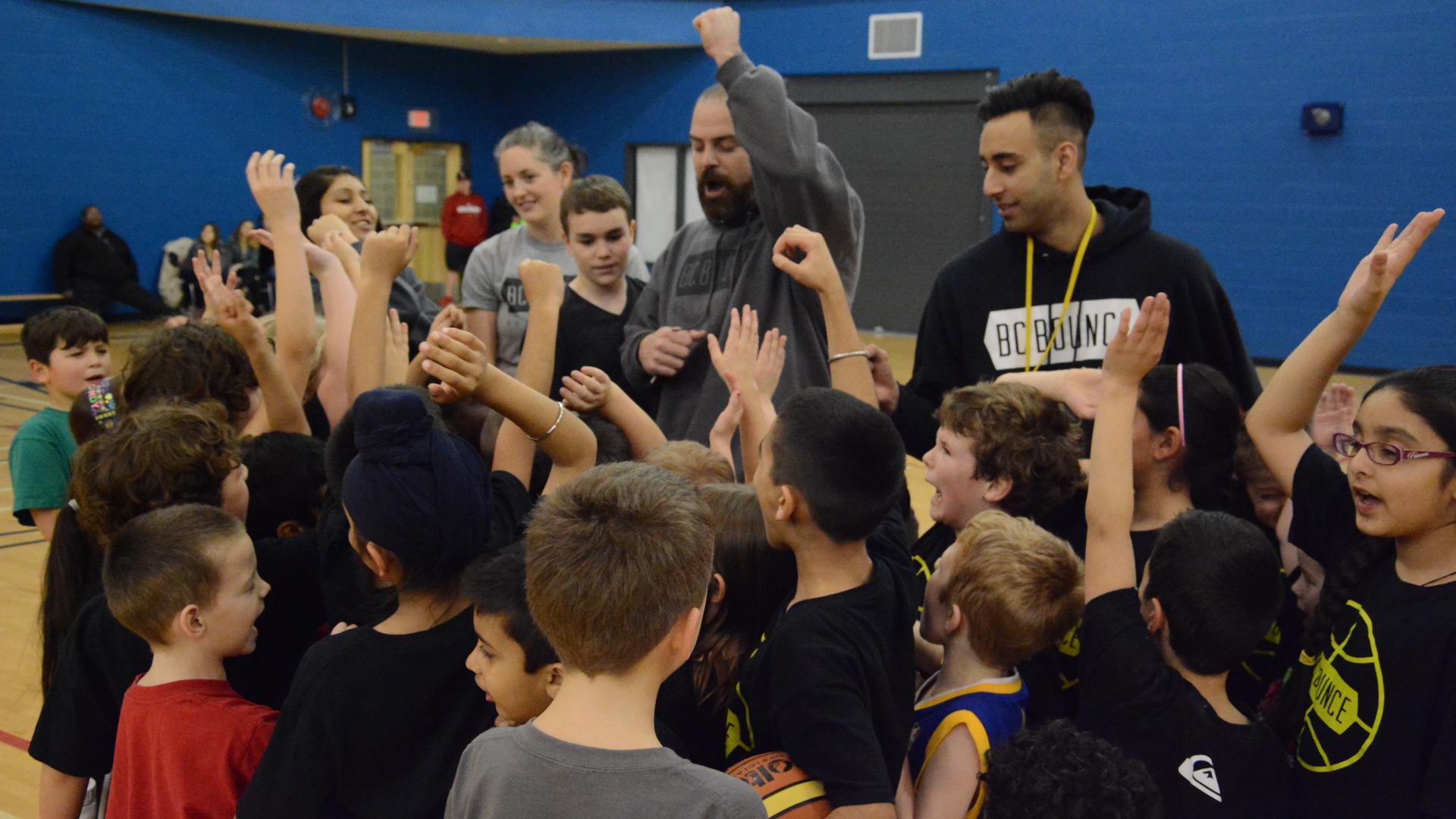 A staff member raises his hand, a gesture imitated by the young boys in front of him at the Greg Moore Youth Centre.