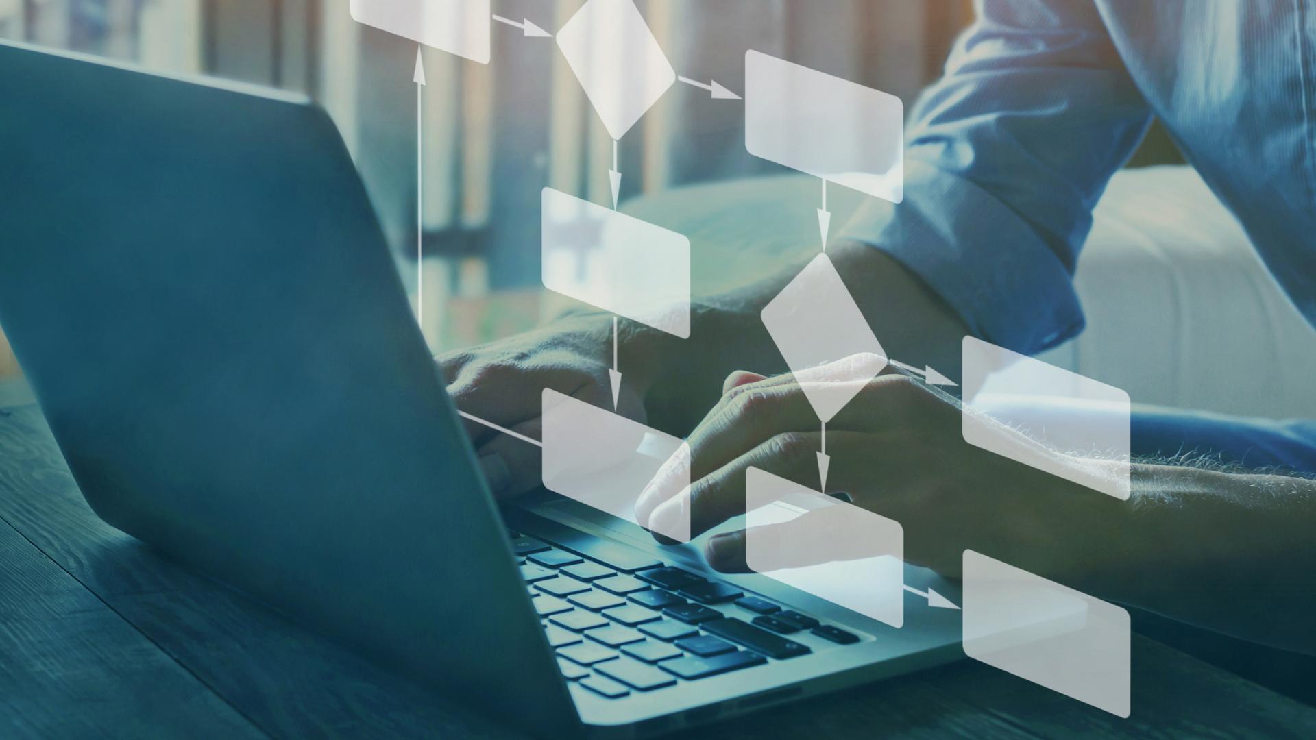 A man types on his laptop, while a flow chart jumps off the screen.