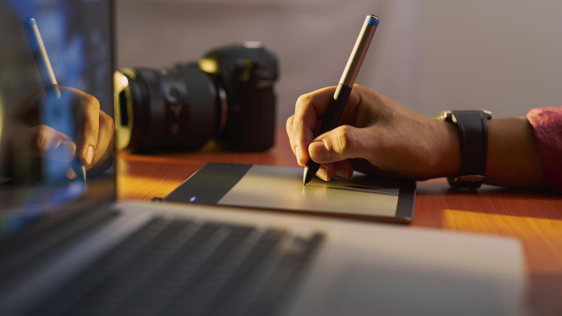 An artist utilizes a drawing tablet and pressure-sensitive stylus to create digital artwork.