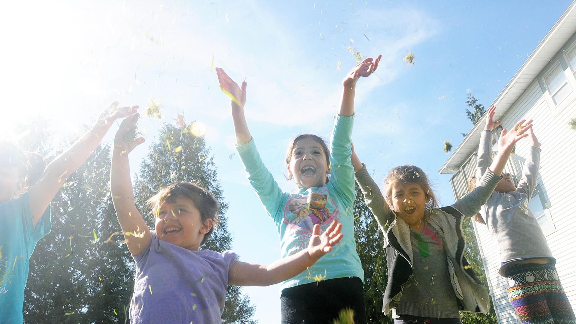 A Group of Children Laughing and Smiling in the Sun
