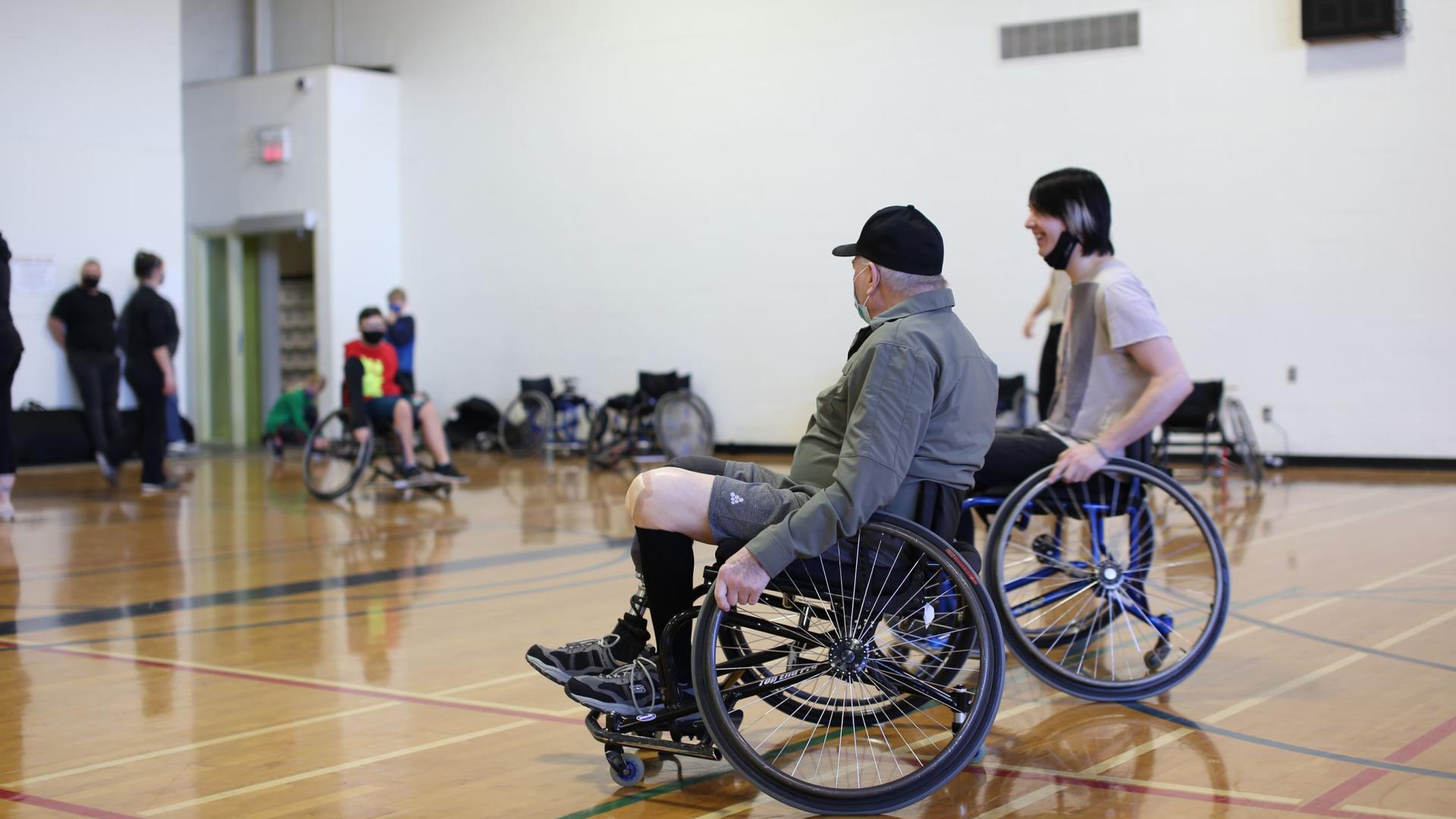 Two wheelchair basketball players, one older and one younger