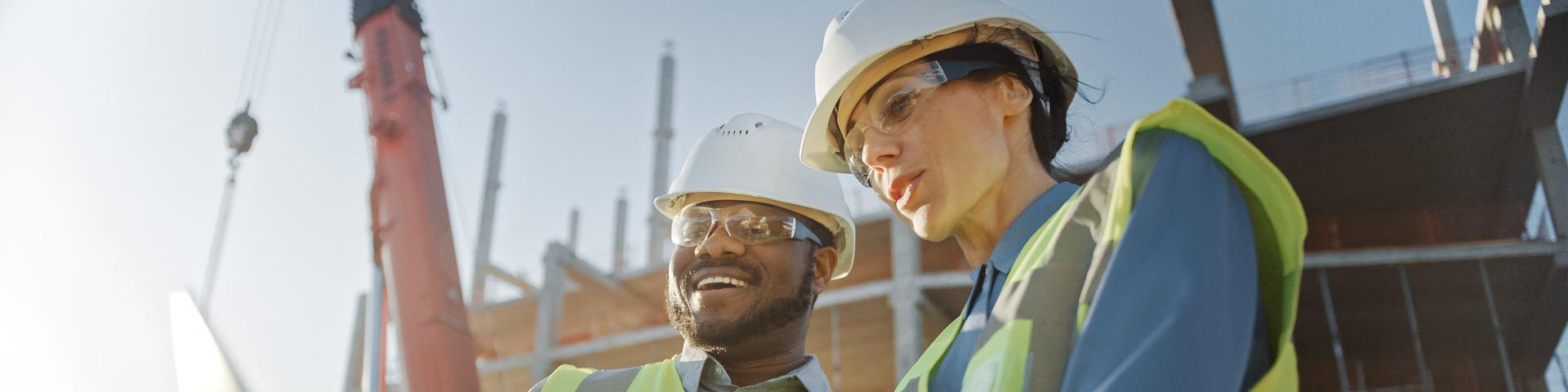 Two construction workers looking at blueprint plan.