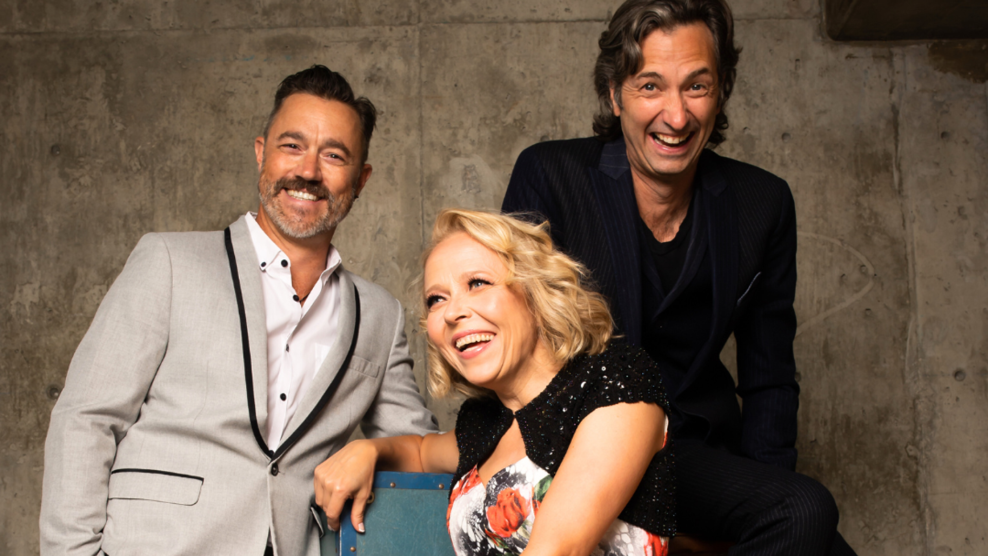 The main cast of the Comedy Department's My Funny Valentine rests in chairs against a concrete background.