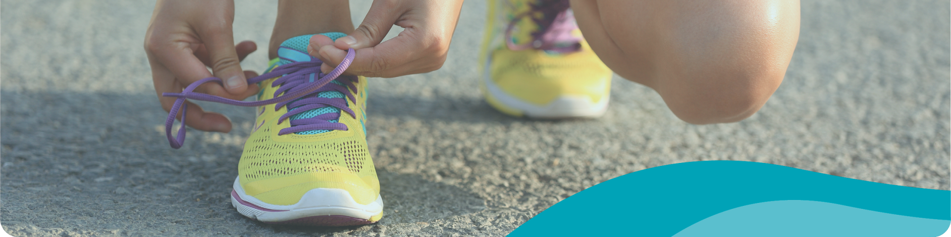 Woman on the Road Kneeling to Tie Her Running Shoes