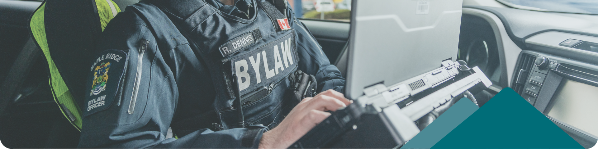 bylaw officer in a car with laptop